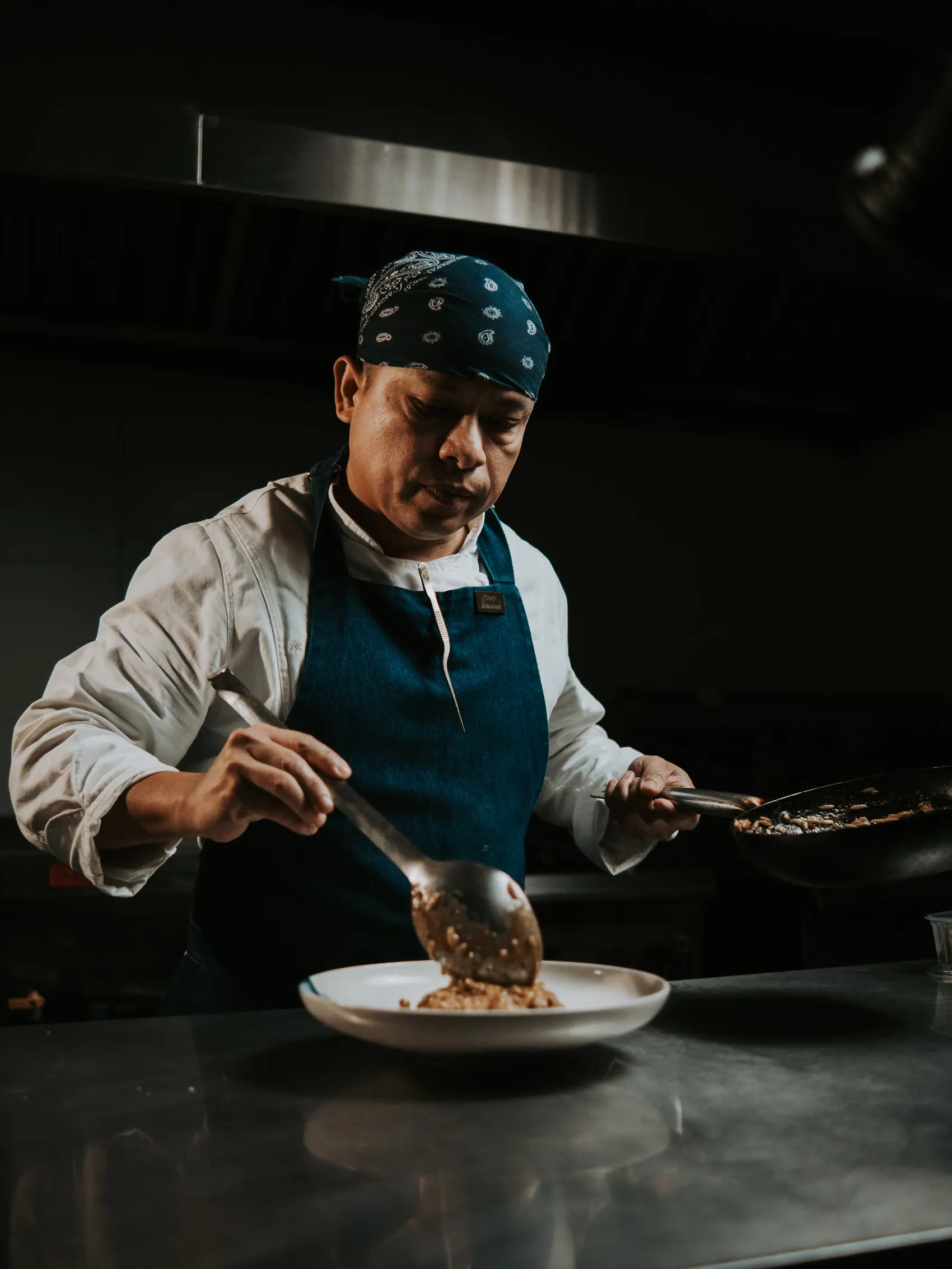 Cozinheiro finaliza o prato na cozinha do Lido di Mare